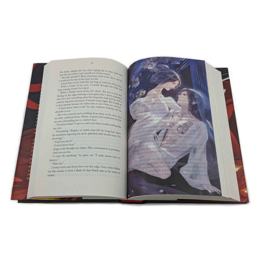 An overhead photo of the Zetian and Yizhi page overlay nested in the middle of an open Iron Widow hardcover. The page overlay is slightly transparent, so the text of the book shows through the overlay.