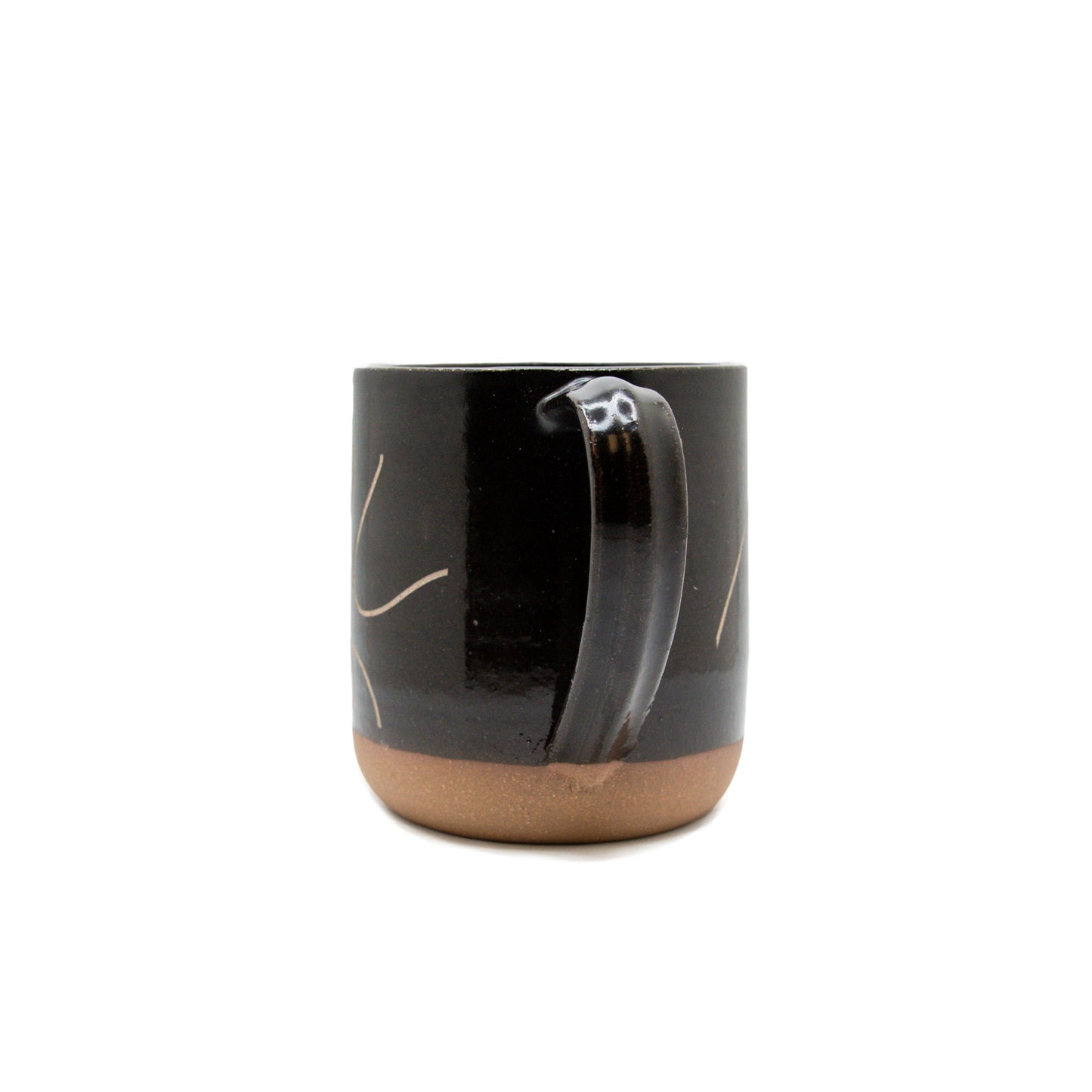 A product photo of the handle side of the dancing dove sandcarved mug. There are a few swirled details on this side, with a solid black handle.