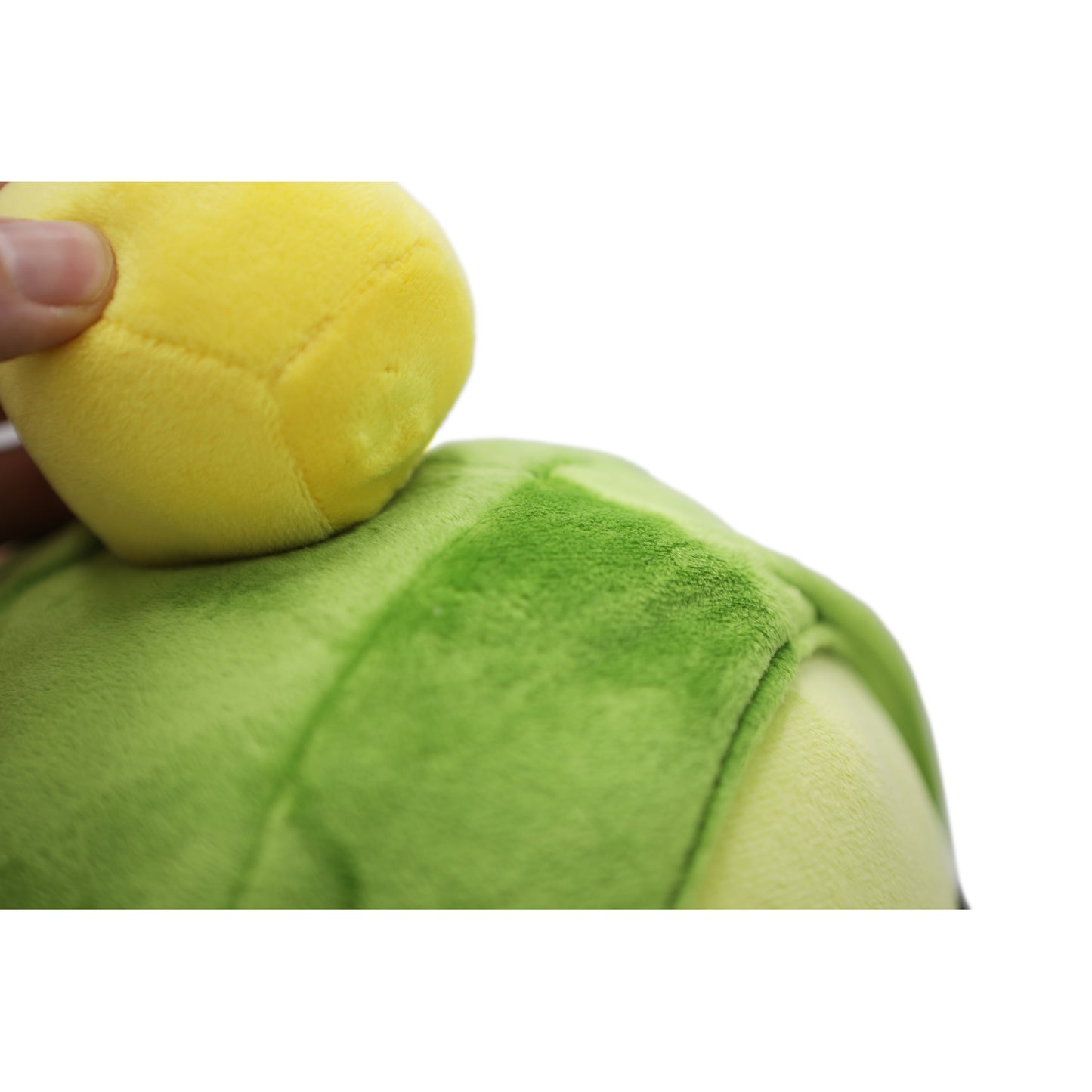 Closeup of hand touching the gold nugget plush atop the Pilfer Plush head.