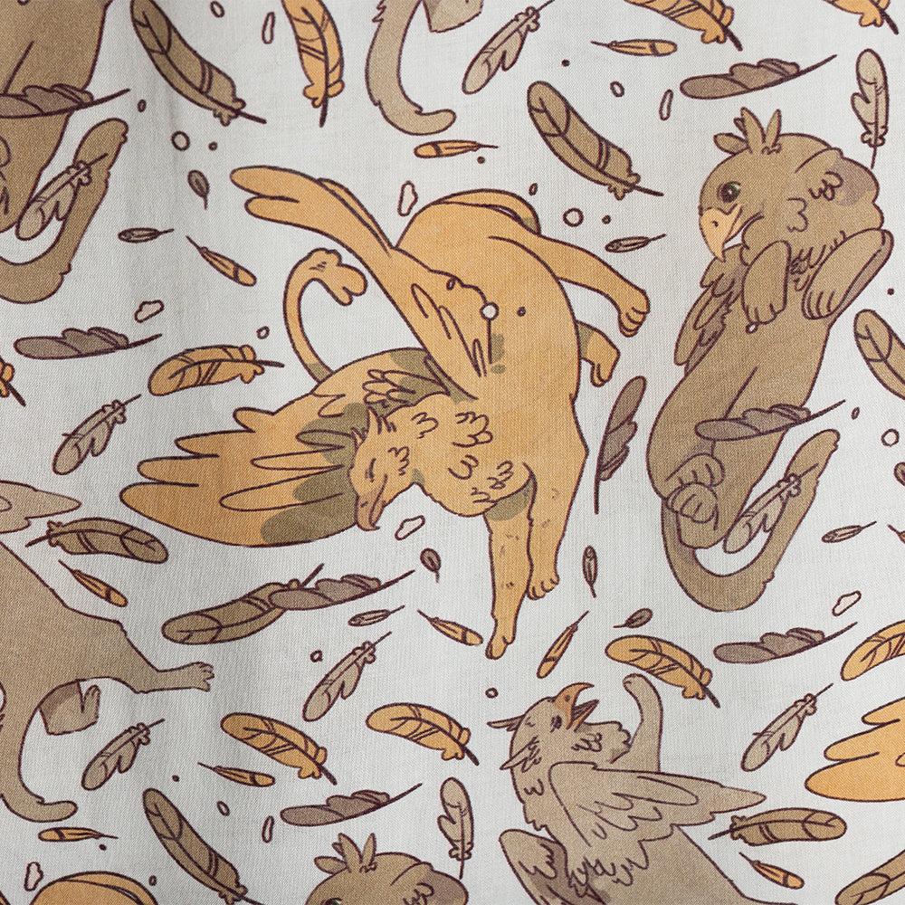 Closeup of Tamora Pierce: Griffins Scarf showing light marigold griffin stetching among feathers and other posing griffins.