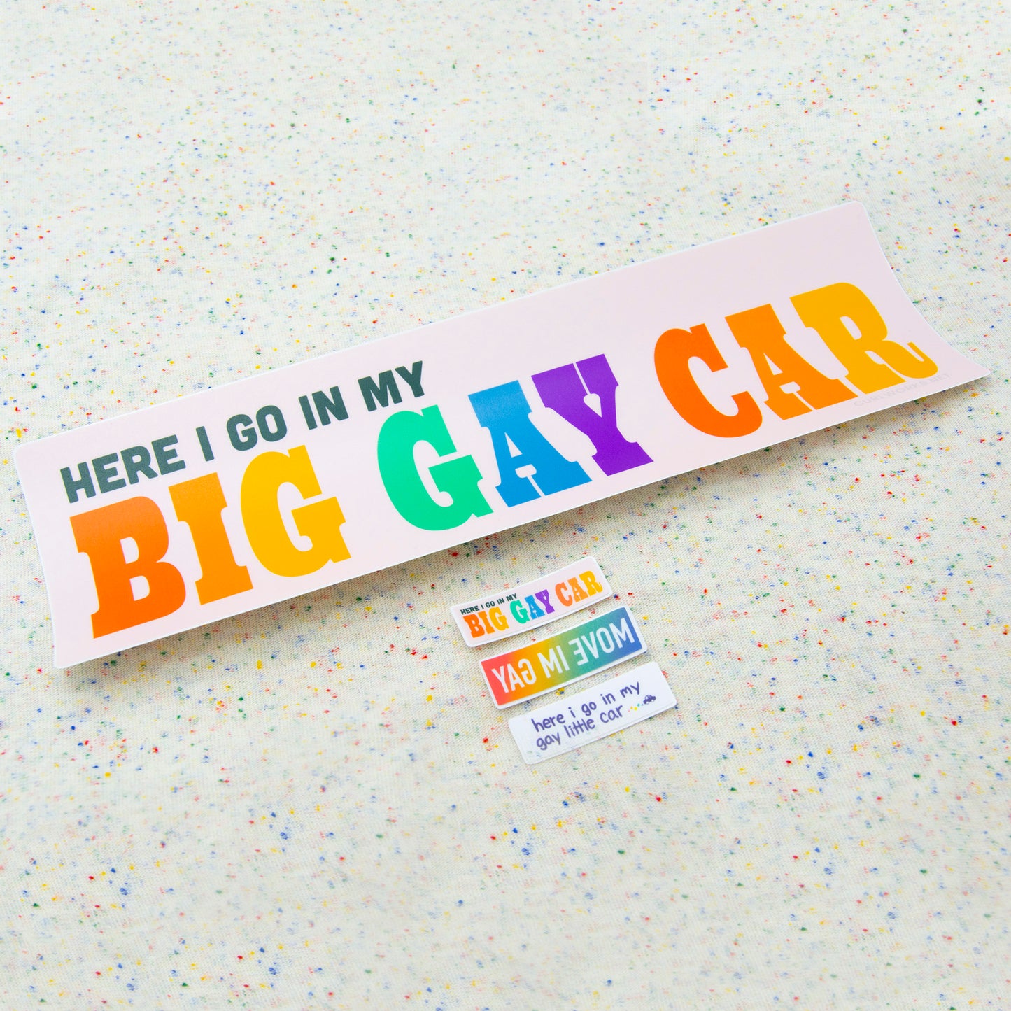 All three mini stickers at an angle together on a funfetti fabric background.