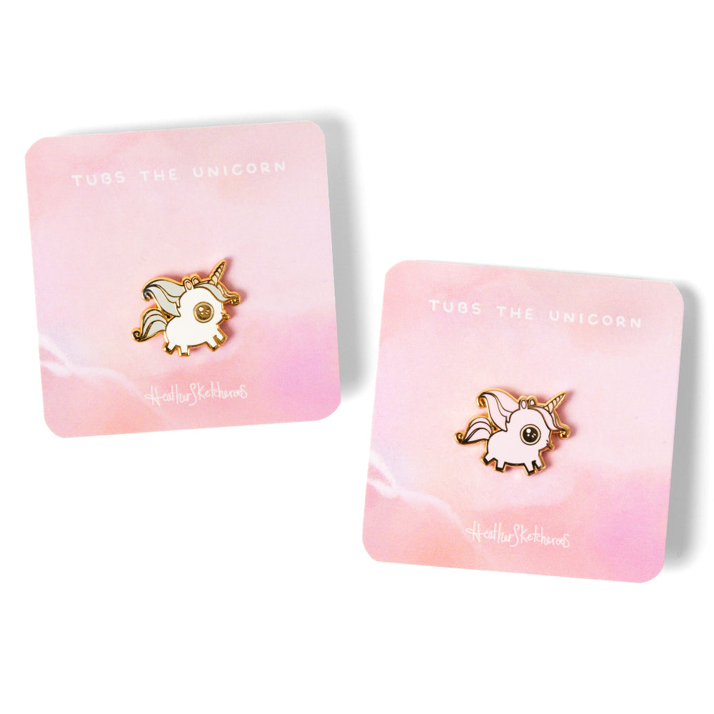 Blue and rose mane variations of Tubs the Unicorn enamel pins on backing cards.