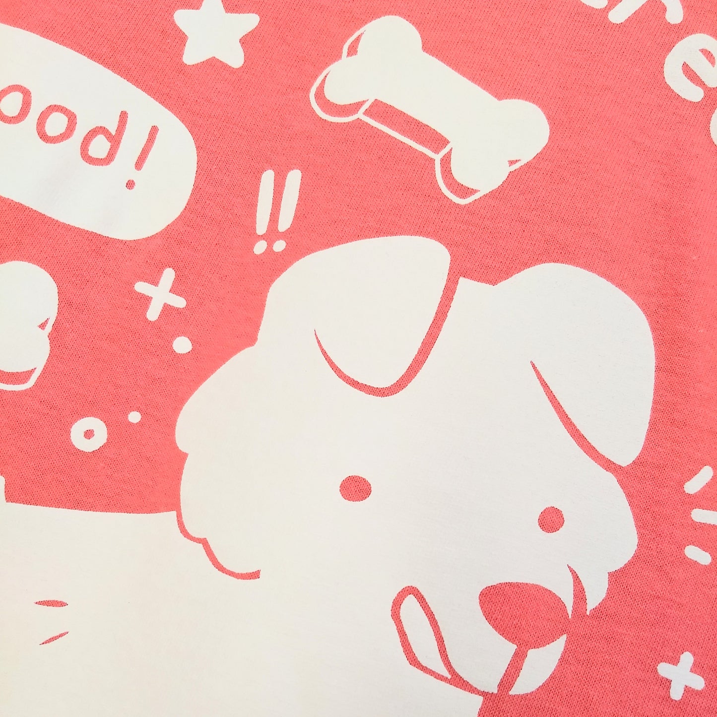 Closeup of the dog's face, licking his chops, on the Motivated By Treats t-shirt.