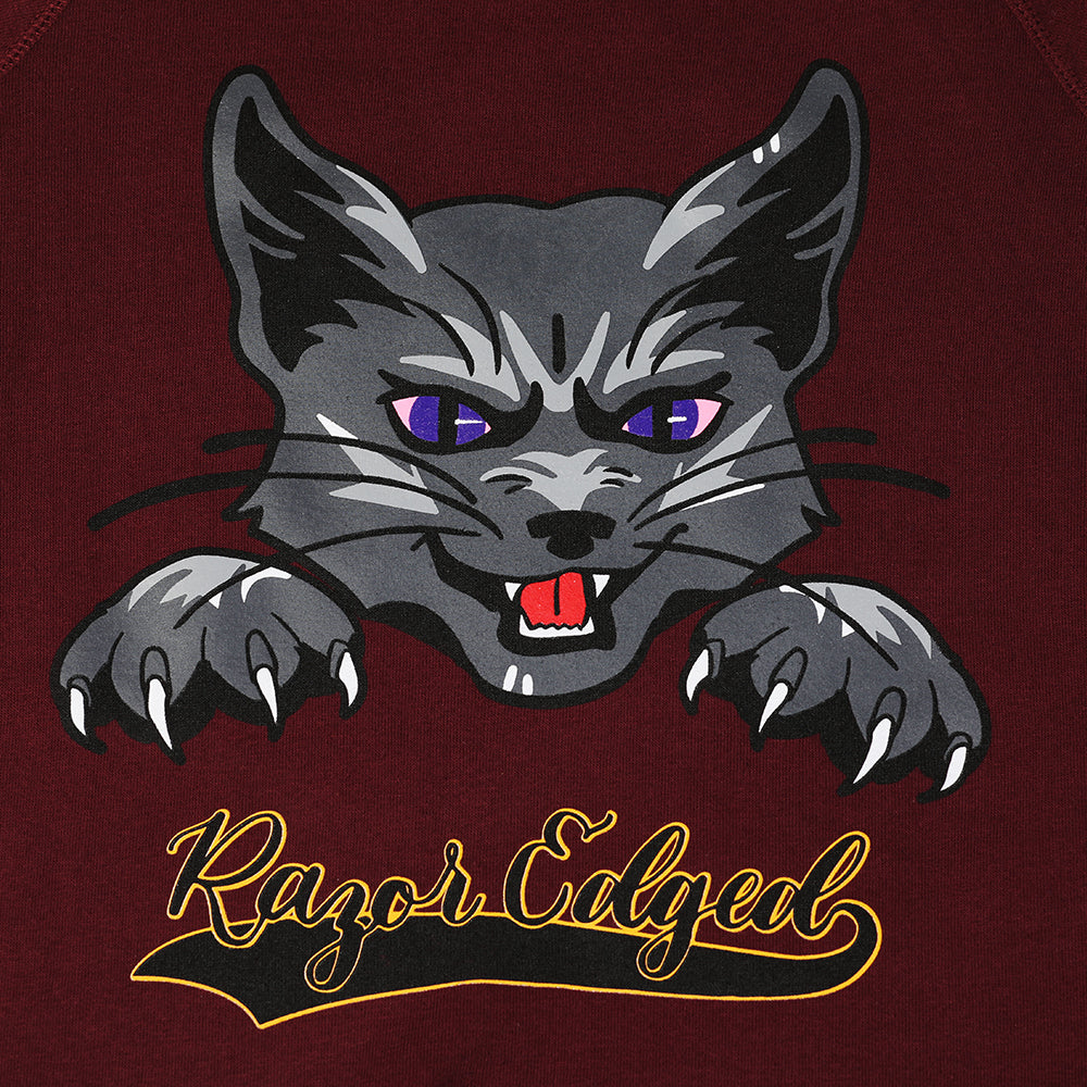 Closeup of grey cat with purple eyes and claws out. Text is black with yellow stroke and reads: "Razor Edged."