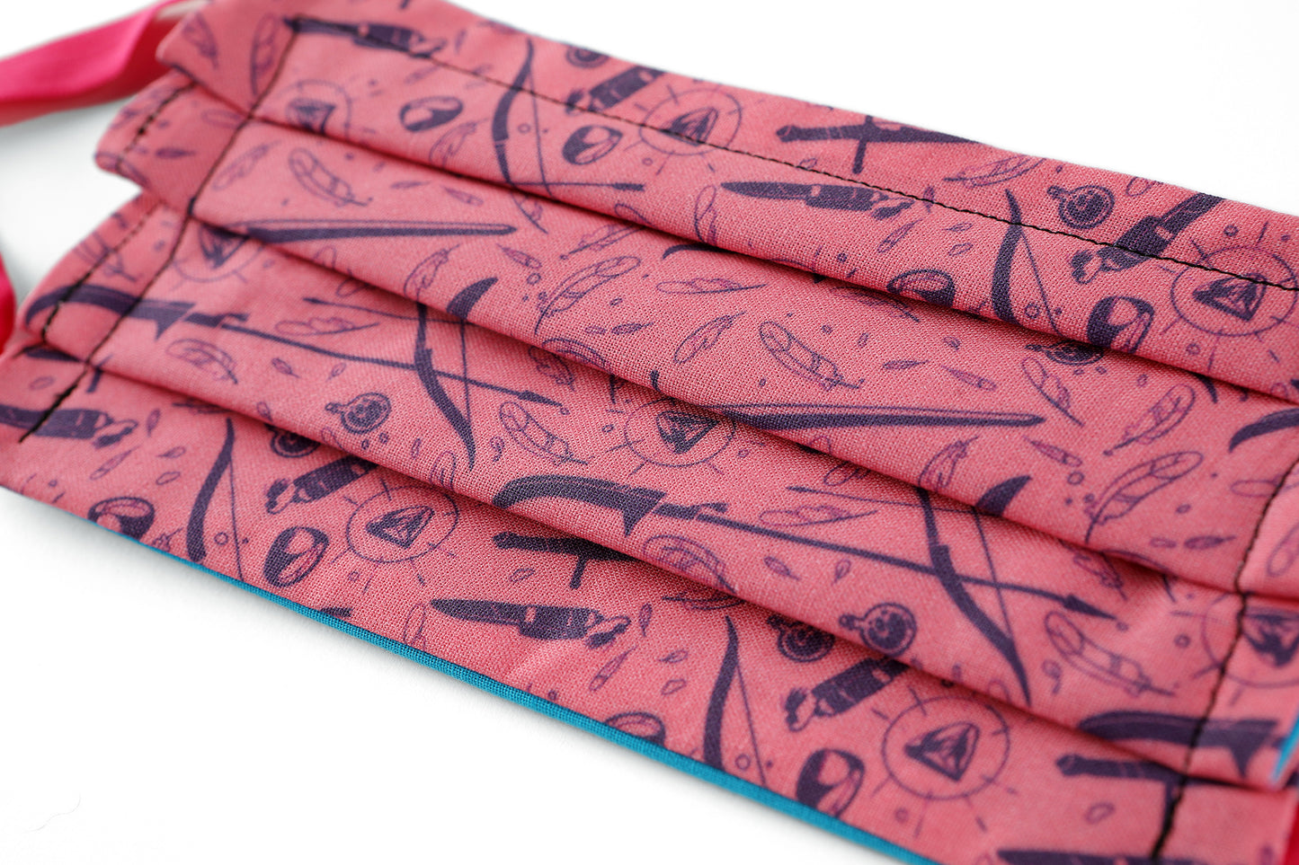 Detail of Front of light pink Tamora Pierce: Weapons & Spells mask with navy pattern.