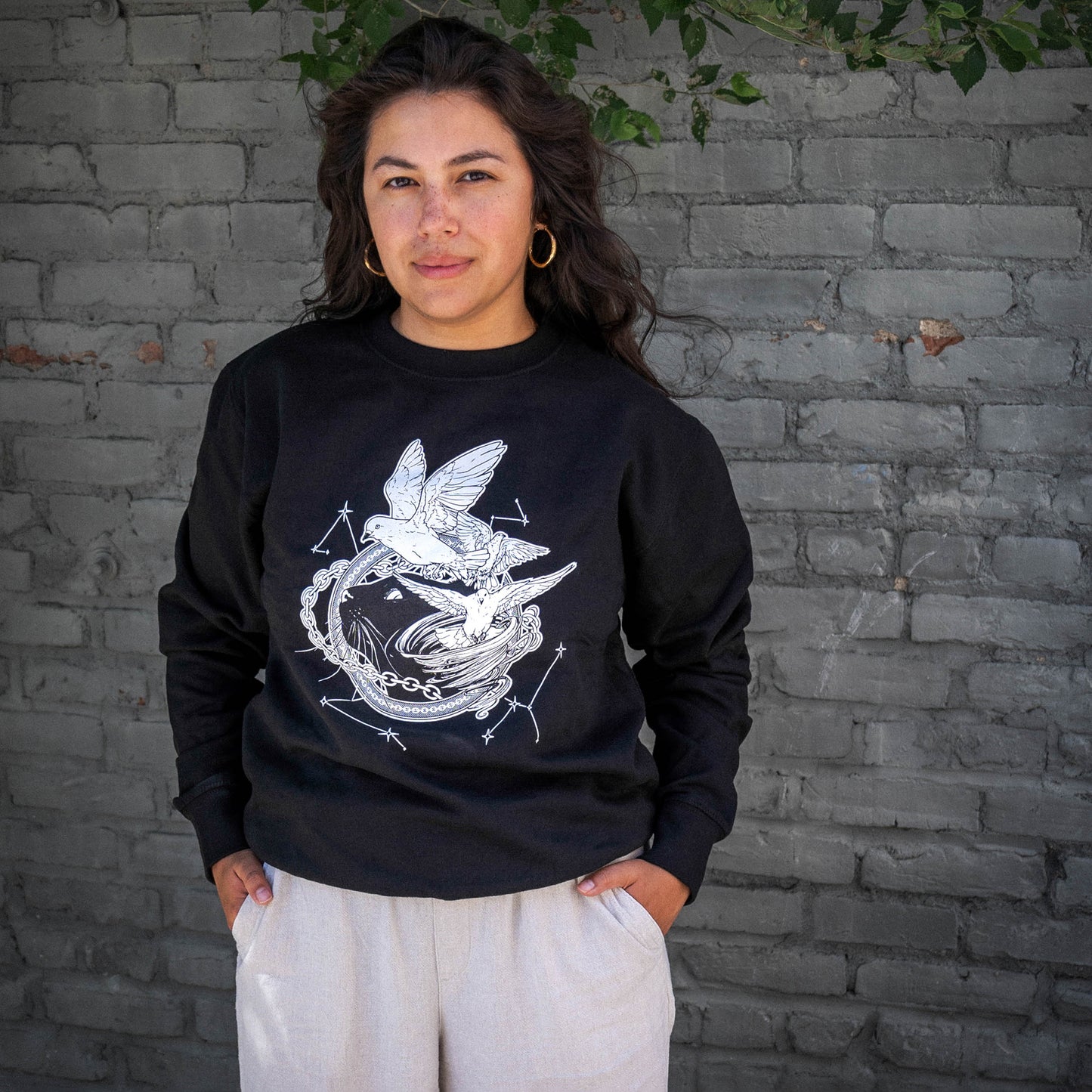 A model wearing the Faithful and the Dust Spinners black sweatshirt paired with stone white sweatpants..