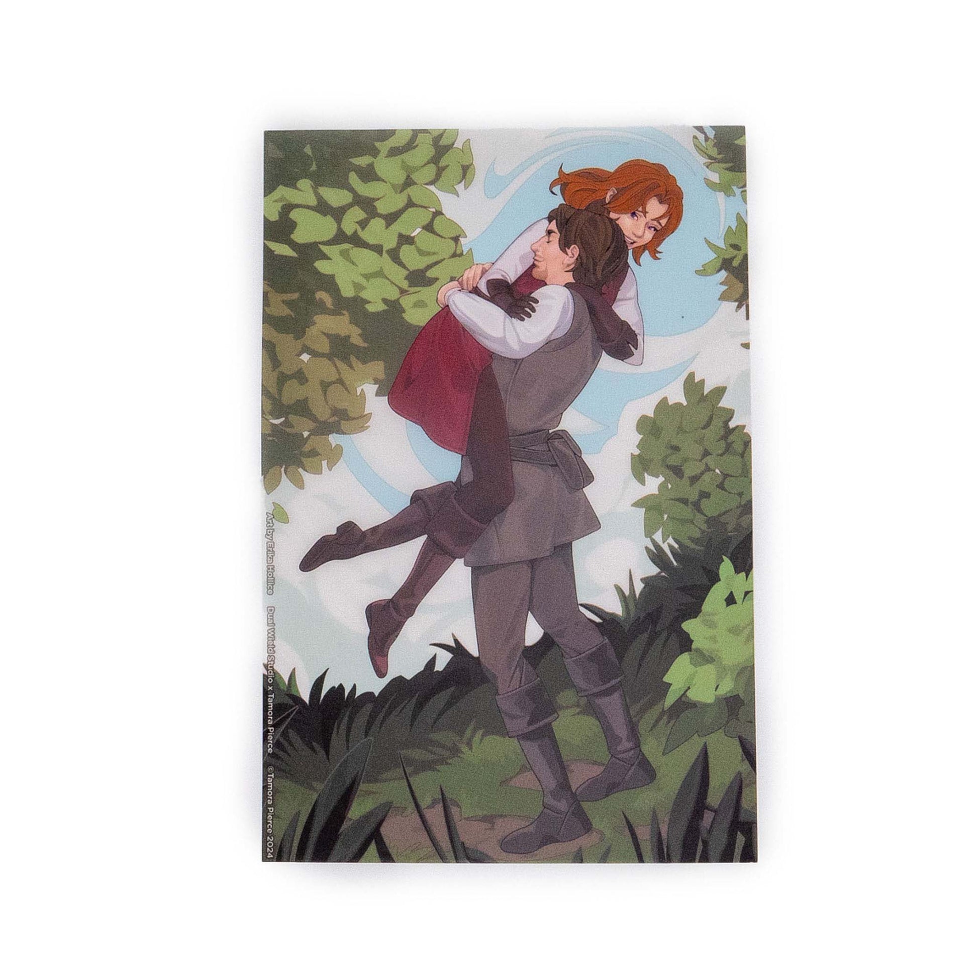 A product photo of the Alanna’s Reunion with George illustrated page overlay. George lifts Alanna in the illustration, both figures tilted amongst forest greenery.