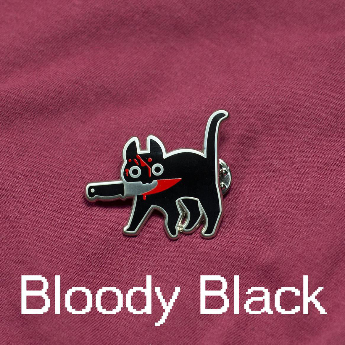 Alternate version of Silver enamel pin of black cat holding knife in mouth and covered in blood. Caption text reads: "Bloody Black" on maroon cloth background.