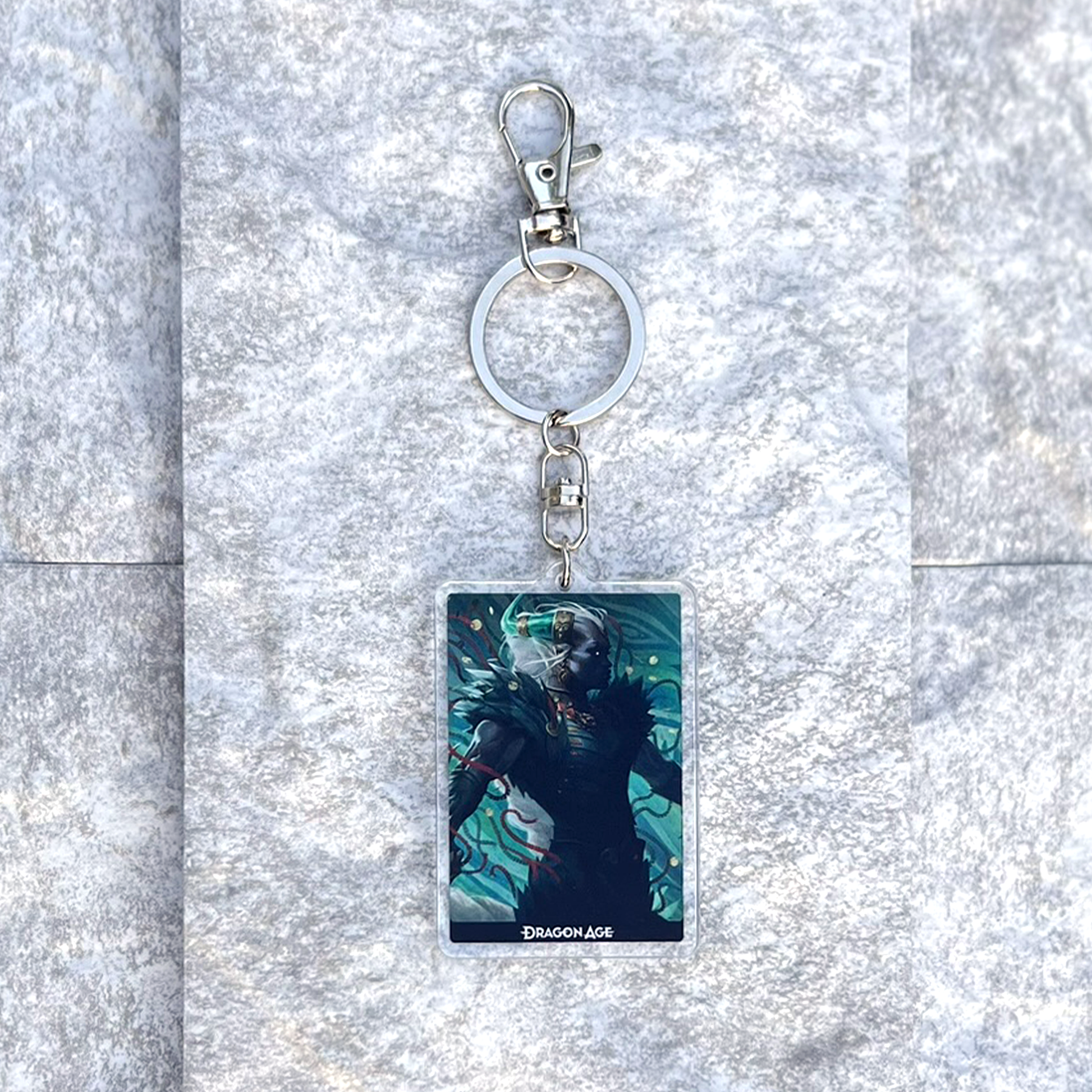 A photo from above of the Taash acrylic keychain on white granite.