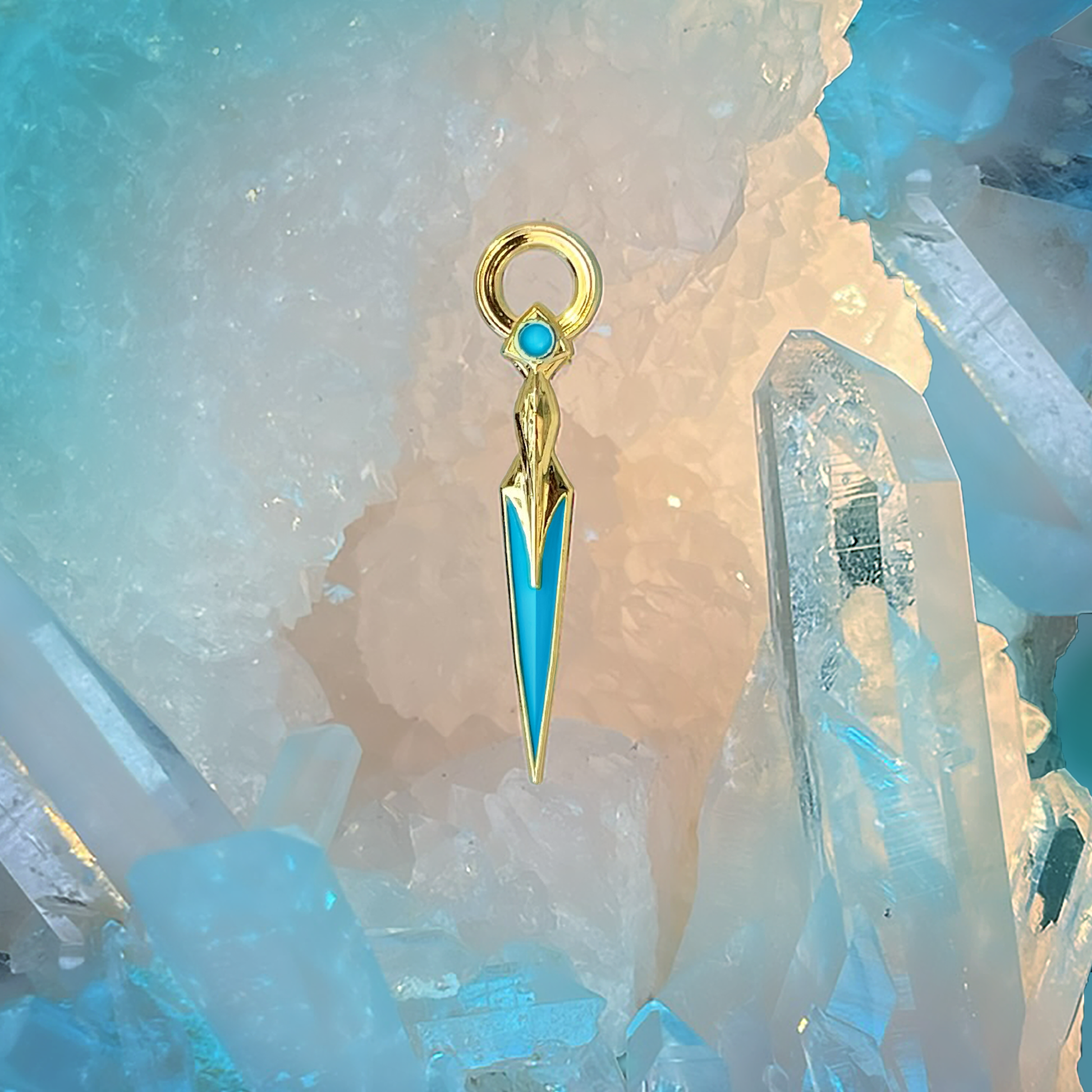 A photo from above of the Blue Lyrium Dagger Enamel Pin, which is pointed downward on a background of blue and clear crystals.