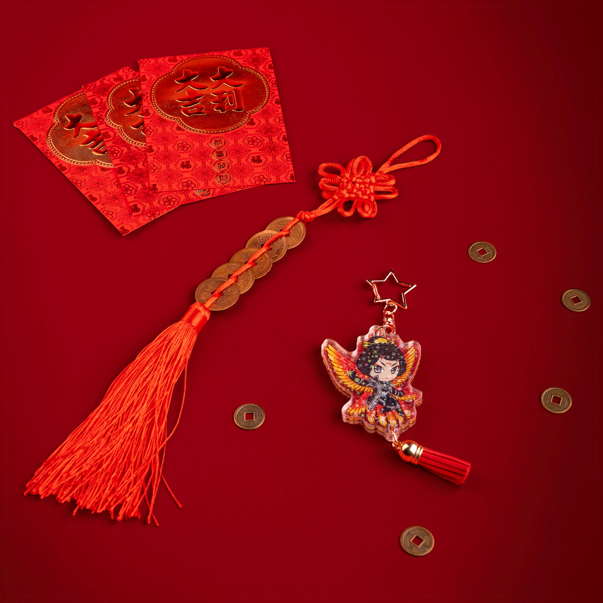 A photo from above of Side 1 of the Zetian Holographic Charm. Zetian is illustrated with black and white jacketed outfit and fiery-colored bird wings behind them. The charm has a star shaped clasp, a red tassel, and the acrylic has a holographic effect. The charm is surrounded by scattered coins.