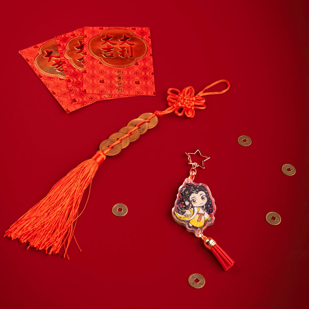A photo from above of Side 2 of the Yizhi Holographic Charm. Yizhi is illustrated in white and yellow traditional clothing. The charm has a star shaped clasp, a red tassel, and the acrylic has a holographic effect. The charm is surrounded by scattered coins.