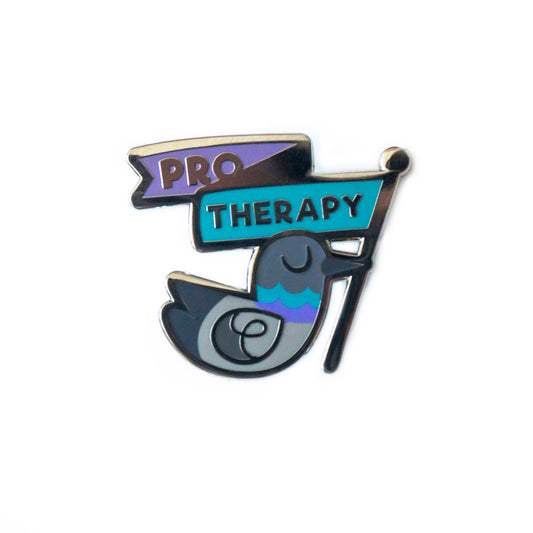 A product photo of an enamel pin depicting a grey pigeon in profile with its eyes closed, holding a flag in its beak. The flag is a twisting ribbon that says “Pro Therapy” in purple and teal. It matches colorful details on the pigeon’s neck, also in purple and teal.