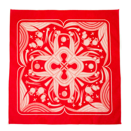 A flat lay photograph of the red Sacred Blood Bandana. The bandana is printed with faded pinks and creams, illustrating lily of the valley, sparkles and lilly of the valley leaves in the four mirrored quadrants.