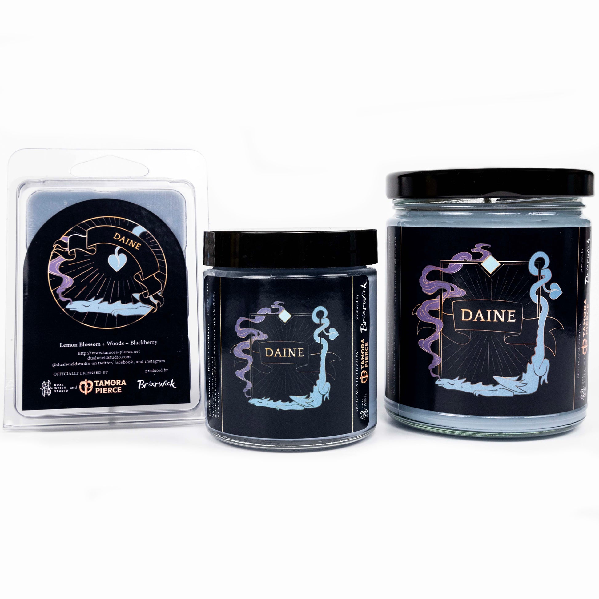 Full set of both Daine candles and wax melts, all with teal wax. The label illustrations depict a snoozing dragon breathing out purple smoke in a rectangular design. Daine is emblazoned across a central ribbon.