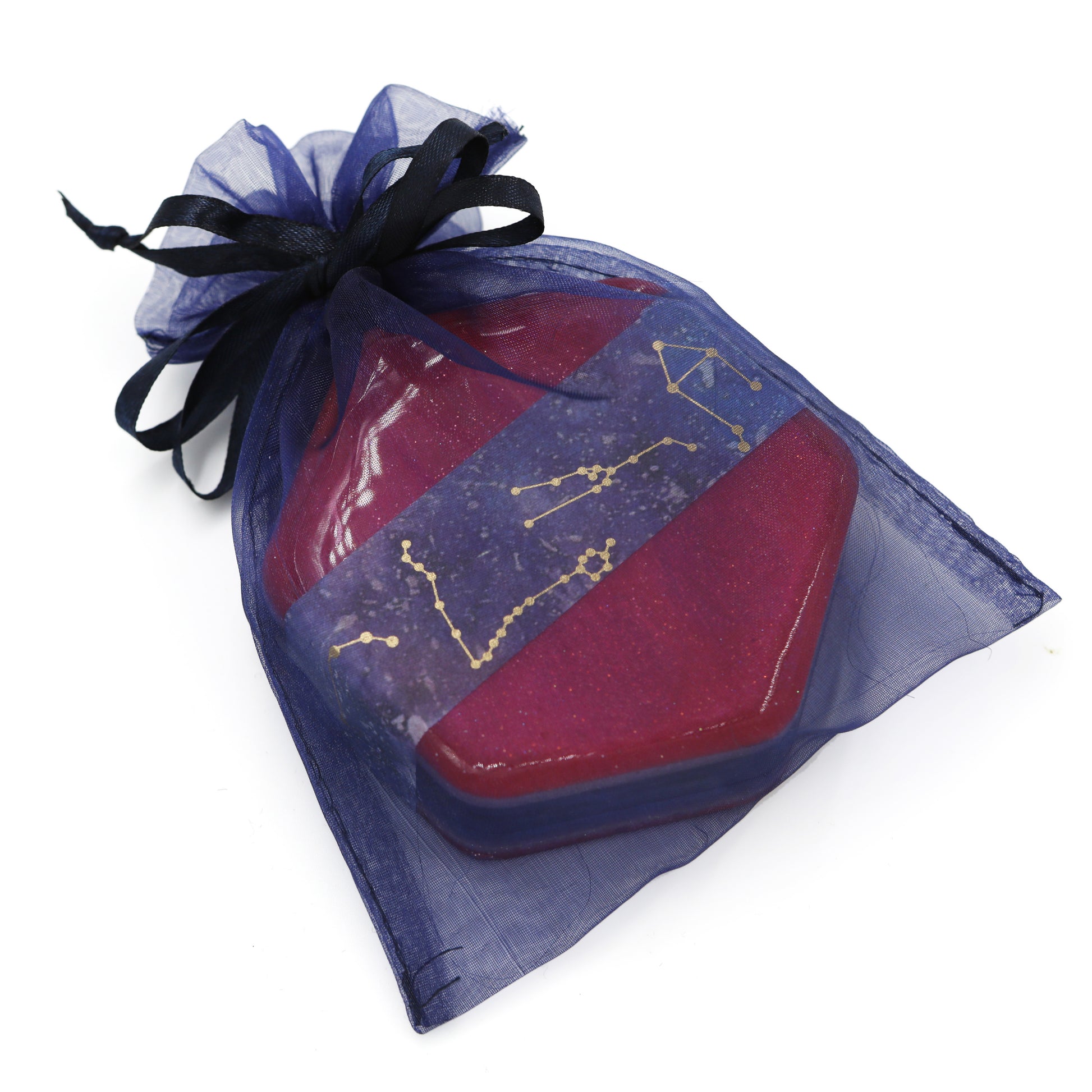Hexagonal acrylic dice box in purple mesh gift bag.