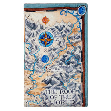 Load image into Gallery viewer, Tamora Pierce Sherpa-lined Tortall Map blanket folded into a rectangle, showing the top-right corner of the map illustration.
