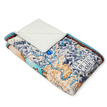 Load image into Gallery viewer, Angled view of the Tamora Pierce Sherpa-lined Tortall Map blanket folded into a rectangle.