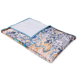 Angled view of the Tamora Pierce Plush Tortall Map blanket folded into a rectangle.