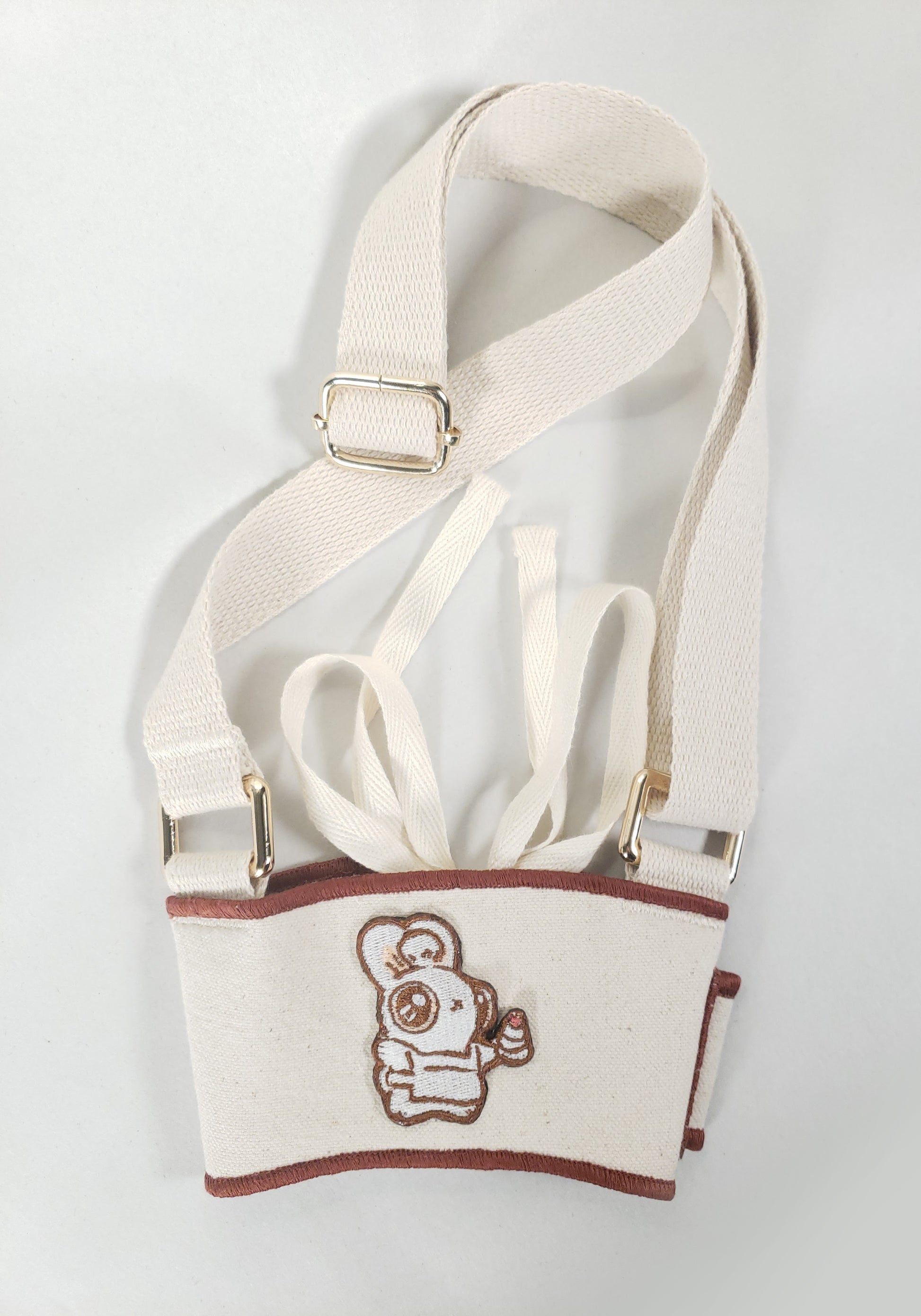 Linen color cloth cup holder with Baker Bunneh as an embroidered patch.