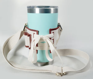 Back view of lacing on Linen color cloth cup holder with Baker Bunneh as an embroidered patch holding a mint green coffee tumbler.