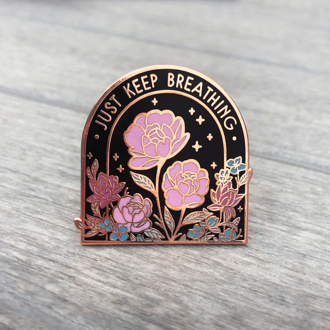 Front view of rose gold flowers pin with text that reads 