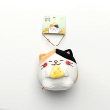 Load image into Gallery viewer, Camang (calico cat with cheese) keyring hanging from tag on white background.