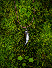 Load image into Gallery viewer, Silver badger claw pendant on brown necklace cord on a lush bed of moss.