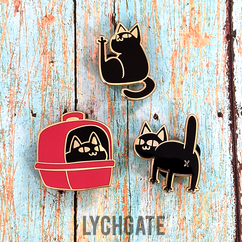 Three different black cat pins are grouped together. One cat is smiling in a red covered litter box. One is proudly showing off its butthole. The last cat sits peering over its shoulder, making direct eye contact with its leg straight in the air.