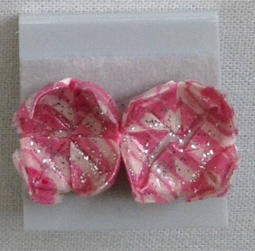 Sparkly pink with stripes paper lotus earrings on white background