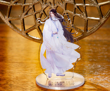 Load image into Gallery viewer, Yizhi acrylic standee with warm wood and gold decoration in background.