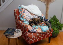Load image into Gallery viewer, A wider shot of a calico cat taking a nap on the Tortall blanket.
