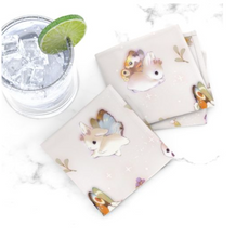 Load image into Gallery viewer, Small pile of Woodsy Jackalope cloth cocktail napkins on marble table beside sparkling drink with lime wedge.