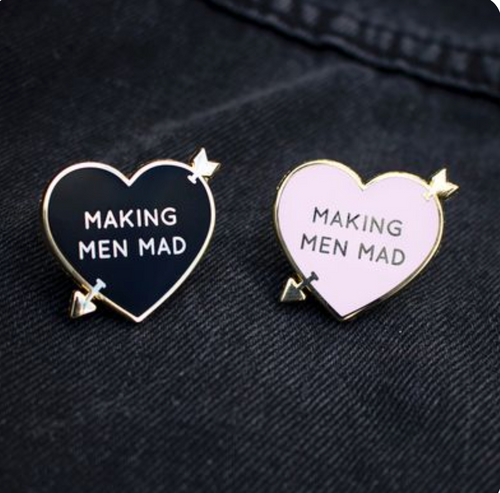 Pink and black variations of gold arrow-pierced, heart-shaped enamel pins with 