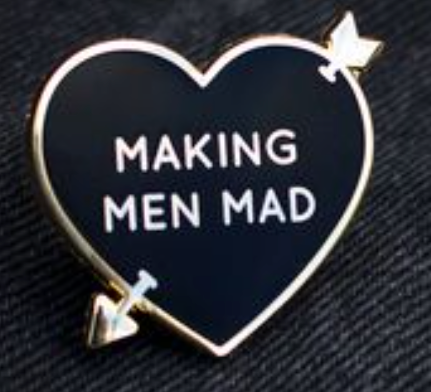 Gold and black enamel pin of heart with arrow piercing it, reading "Making Men Mad."