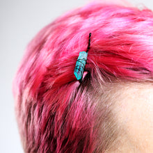 Load image into Gallery viewer, Light blue crystal on black pin on model with bright pink hair.