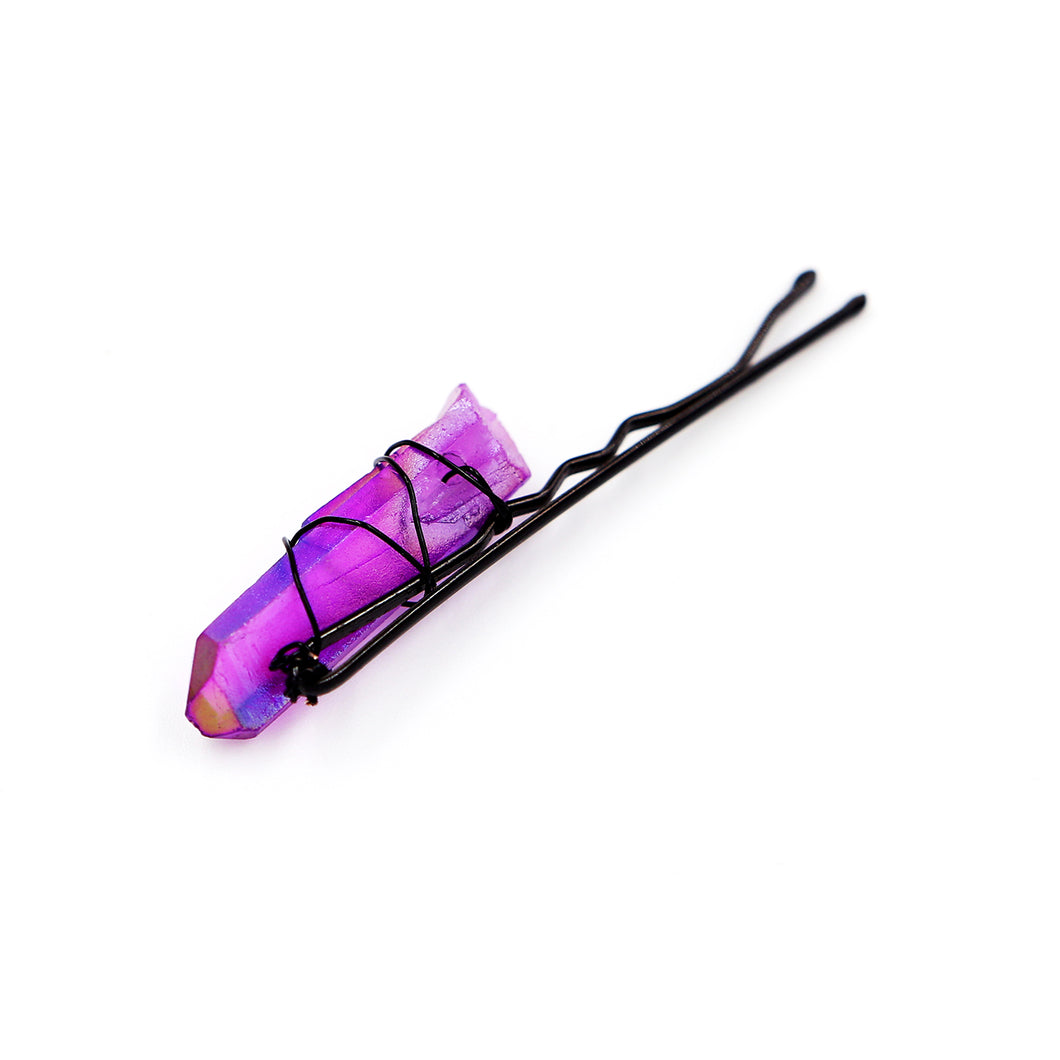 Purple crystal on black pin on white background.