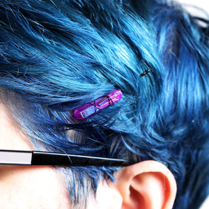 Purple crystal on black pin on model with blue hair.