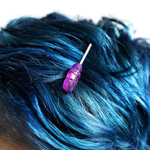 Purple crystal on pink pin on model with blue hair.