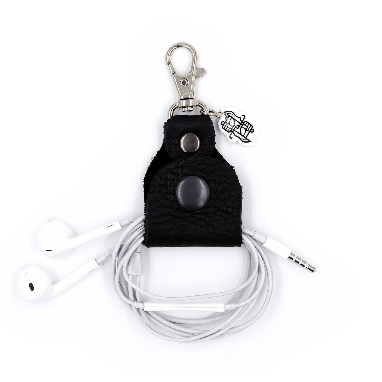 Black leather headphone keepers with Dual Wield Studio logo and silver clasp holding white aux headphones on white background.