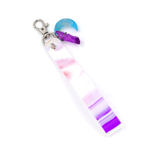 Holographic keystrap with silver clasp and blue moon charm on white background.