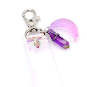 Closeup of pink moon charm attached to keystrap on white background.
