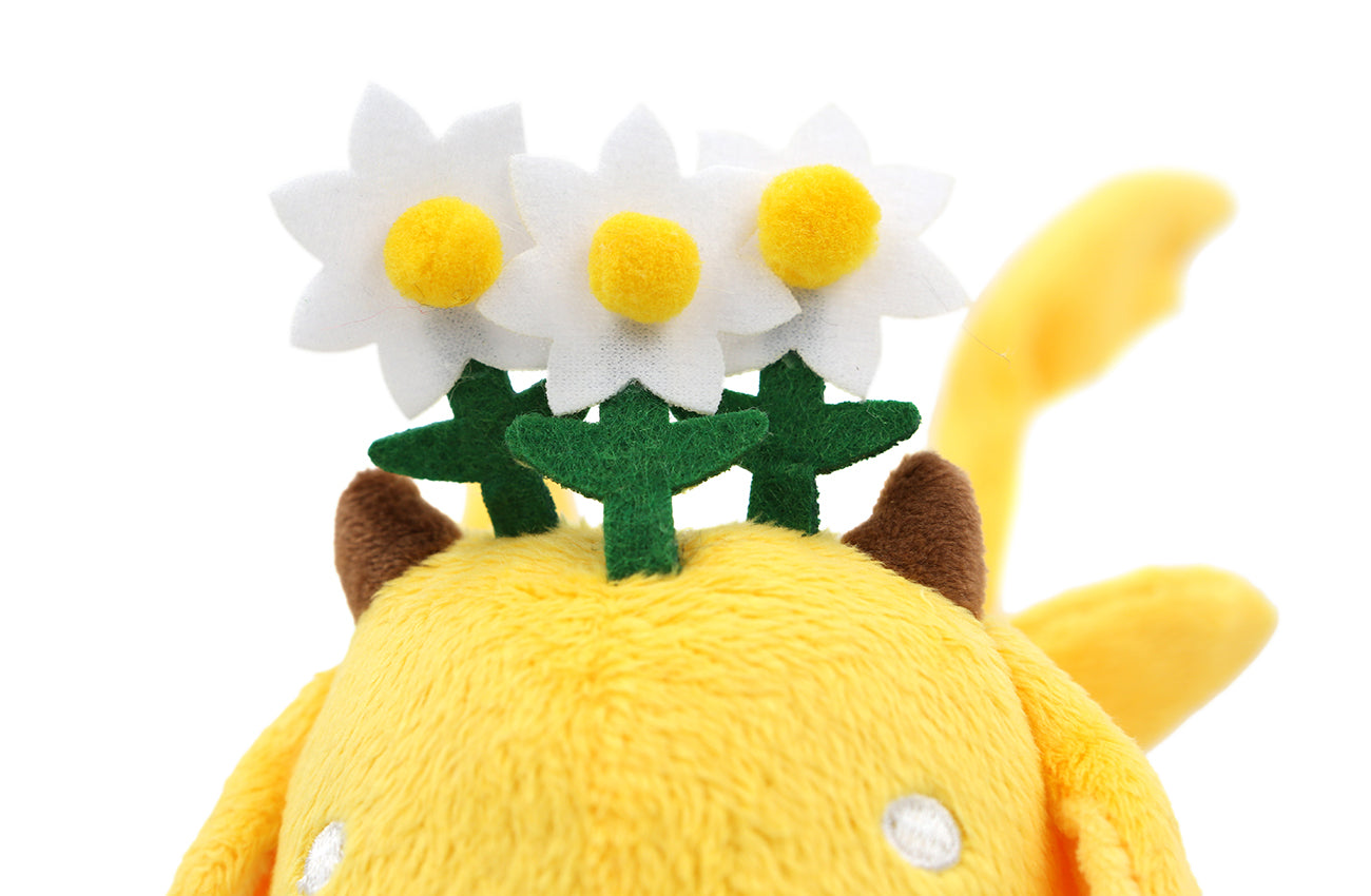 Closeup of Chamomile flowers sitting between two small horns protruding from the top of the plush's head.