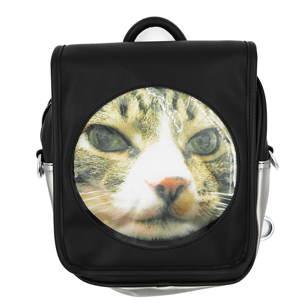 An extreme closeup of a cat's face inserted into the black ita bag.