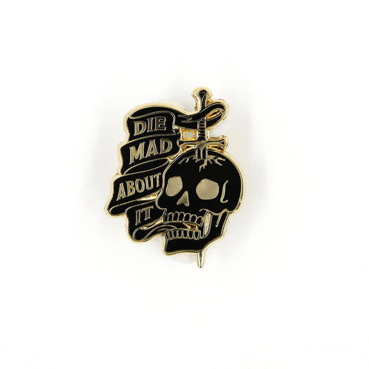 Front view of Die Mad About It sword through skull enamel pin on white background.
