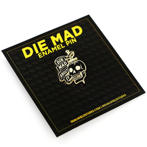 Front view of Die Mad About It sword through skull enamel pin on backing card on white background.