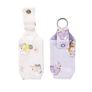 Pastel pink and purple hand sanitizers together on white background.
