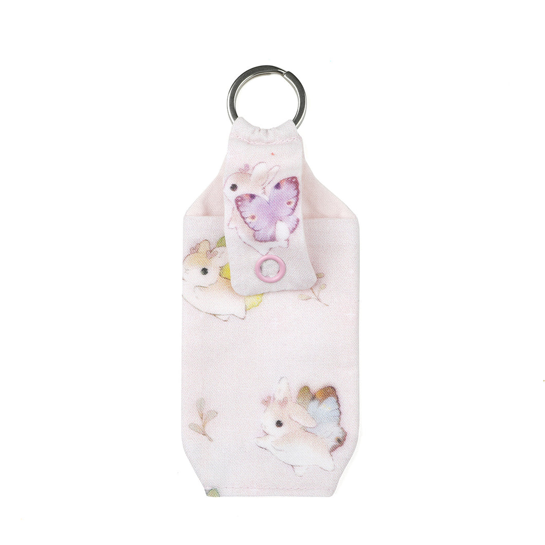 Closed Pastel pink bunnerfly hand sanitizer holder on white background.