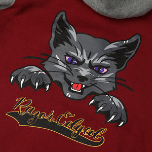 Closeup of grey cat with purple eyes and claws out. Text is black with yellow stroke and reads: "Razor Edged."