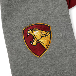 Arm detail of dark red Faithful varsity sweatshirt. Decal is roaring golden yellow lioness in profile framed by marigold and red shield shape.